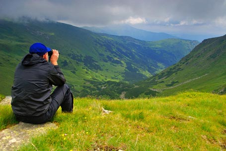 Young Man Viewing Valley with Binocular